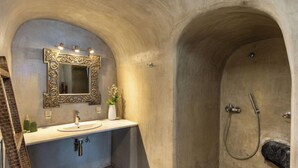 A bathroom with a sink, mirror, and shower. - Santa Irini Villa (Santorini)