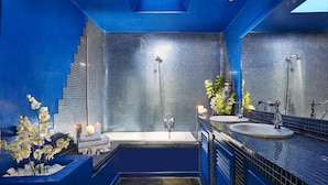 A modern bathroom with a skylight, a bathtub, a shower, and a vanity with a sink. - The Architect's House (Santorini)