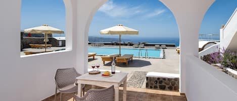 Una terraza con piscina, mobiliario exterior y vistas al mar.