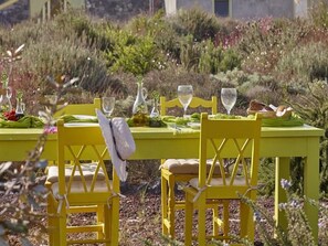 Una mesa de comedor al aire libre con sillas y vajilla.