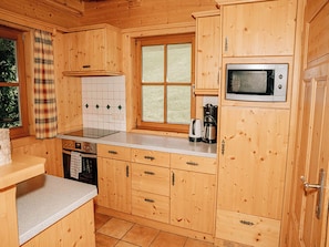 Eine Holz-Küche mit Mikrowelle, Herd und Kaffeemaschine.