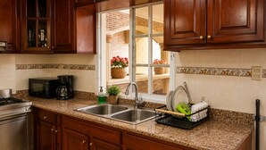 A kitchen with granite countertops, stainless steel appliances, and wooden cabinets. - Vrbo Property (Santo Domingo Este)