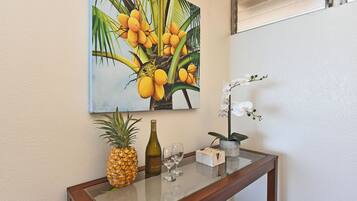 A glass-top table with a pineapple, a bottle, and a small orchid.