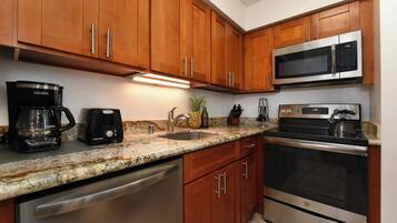 A kitchen with wooden cabinets, a stainless steel dishwasher, a microwave, and an oven.