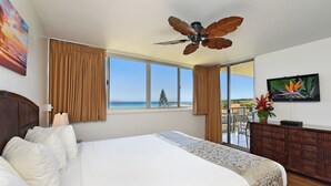 A hotel room with a bed, a ceiling fan, a television, and a view of the sea. - Oceanfront - Luxury View - 2 Beds (Lahaina)