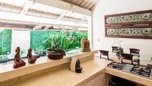 A kitchen with a gas stove, a coffee machine, and a potted plant. - Villa Gembira (Keroboken Kelod)
