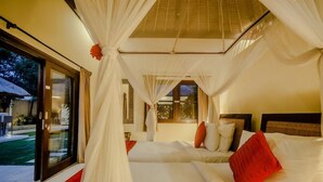 A room with two beds, a large window, and a sliding glass door leading to an outdoor area. - Villa Gembira (Keroboken Kelod)