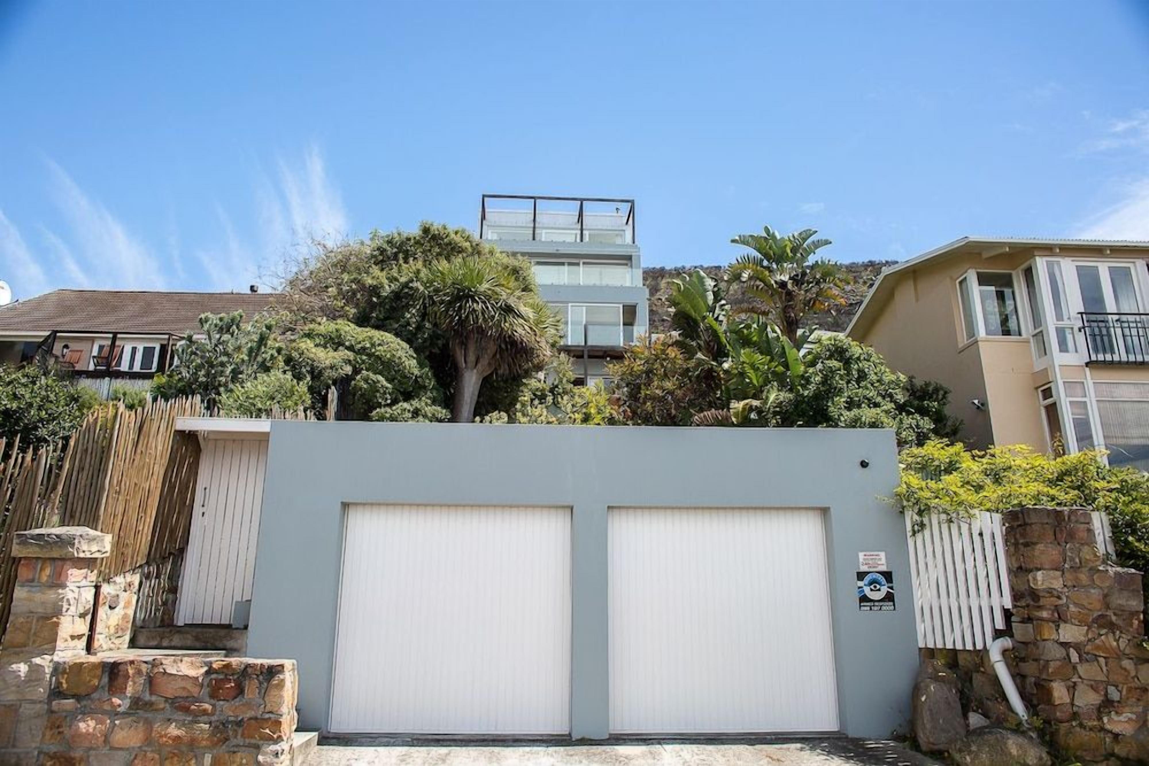 A residential property with a garage, a balcony, and a view of a modern building.