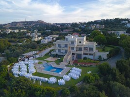 Un hotel moderno con piscina, varias zonas de restauración y vistas del paisaje circundante.