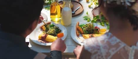 A dining table with plates of food, a bottle of oil, and a jug of milk.