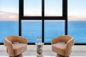Two armchairs facing a large window with a view of the ocean. - The Mojo Ocean Suite Sixty-Sixth Floor, Meriton (Surfers Paradise)