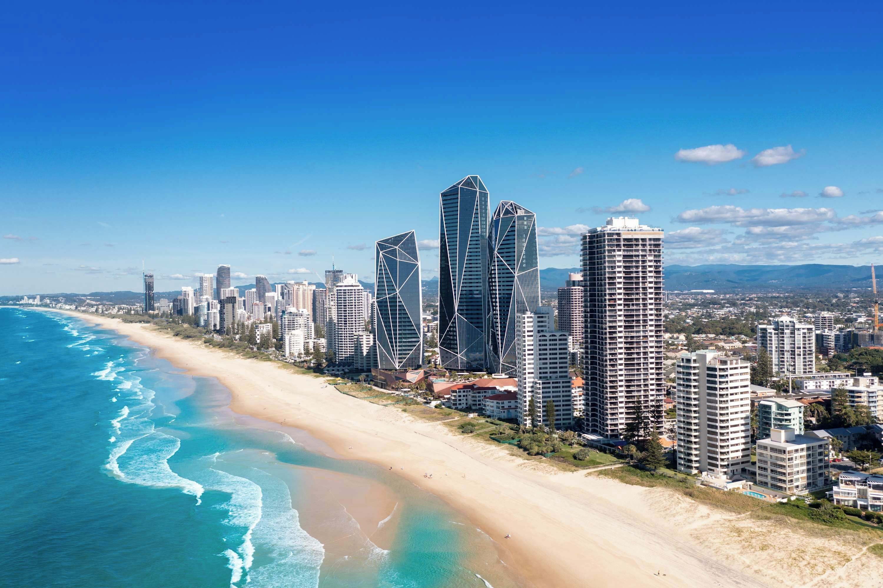 Eine Küstenstadt mit Wolkenkratzern, einem Sandstrand und blauem Himmel.