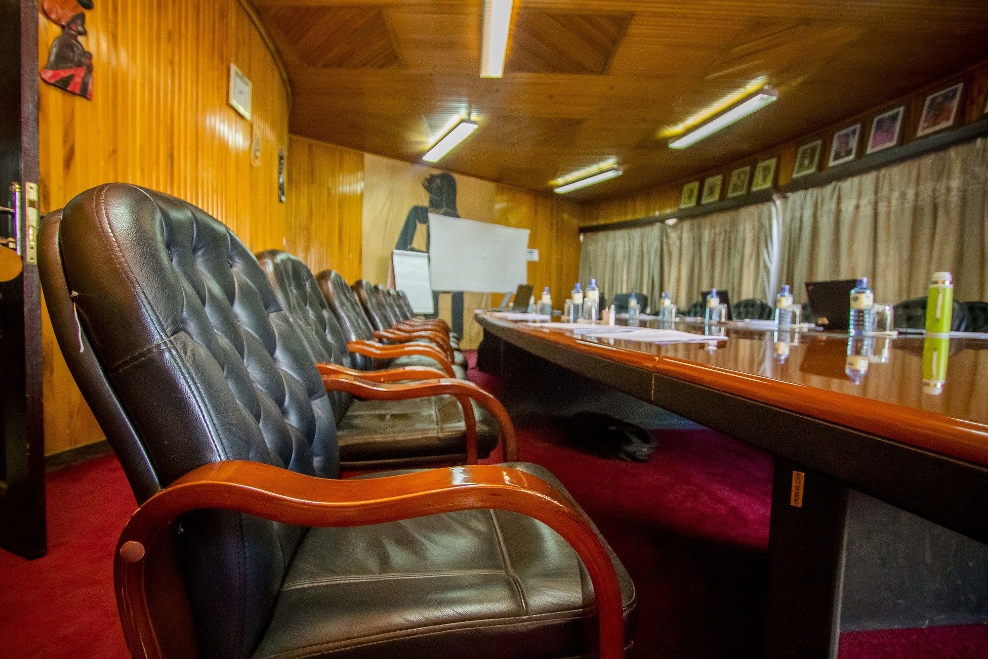 A conference room with leather chairs, a long table, and a projector screen.
