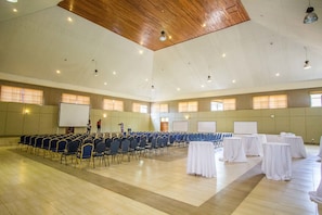 A large hall with rows of chairs and tables, a stage with a whiteboard, and a wooden ceiling. - Desmond Tutu Guest House (Nairobi)