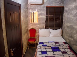 Ein Schlafzimmer mit Bett, Stuhl, Fenster und Tür.