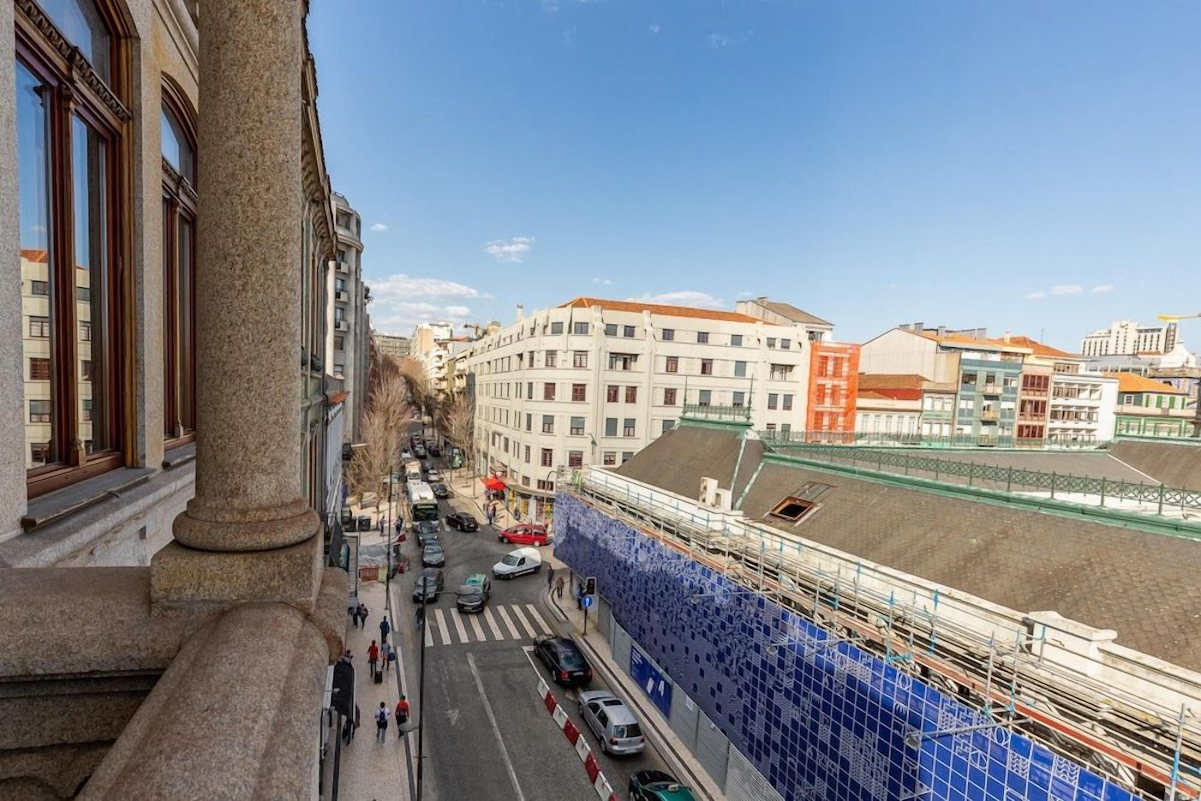 A street view with buildings, a pedestrian crossing, and a construction site with blue scaffolding.