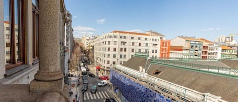 A street view with buildings, a pedestrian crossing, and a construction site with blue scaffolding.