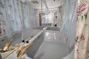 A bathroom with two large tubs, a sink, and a mirror. - Cozy 3-bedroom bed & breakfast in charming Jefferson with AC (Jefferson)