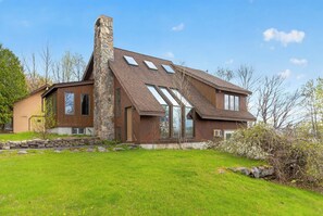 A modern house with a stone chimney, large windows, and a well-maintained lawn. - Cozy 3-bedroom bed & breakfast in charming Jefferson with AC (Jefferson)