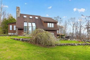 A modern two-story house with a stone chimney, large windows, and a well-maintained lawn. - Cozy 3-bedroom bed & breakfast in charming Jefferson with AC (Jefferson)