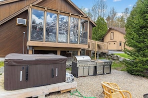 A wooden house with large windows, a hot tub, and a grill area. - Cozy 3-bedroom bed & breakfast in charming Jefferson with AC (Jefferson)