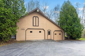 A single-story building with a gabled roof, two garage doors, and a small door. - Cozy 3-bedroom bed & breakfast in charming Jefferson with AC (Jefferson)