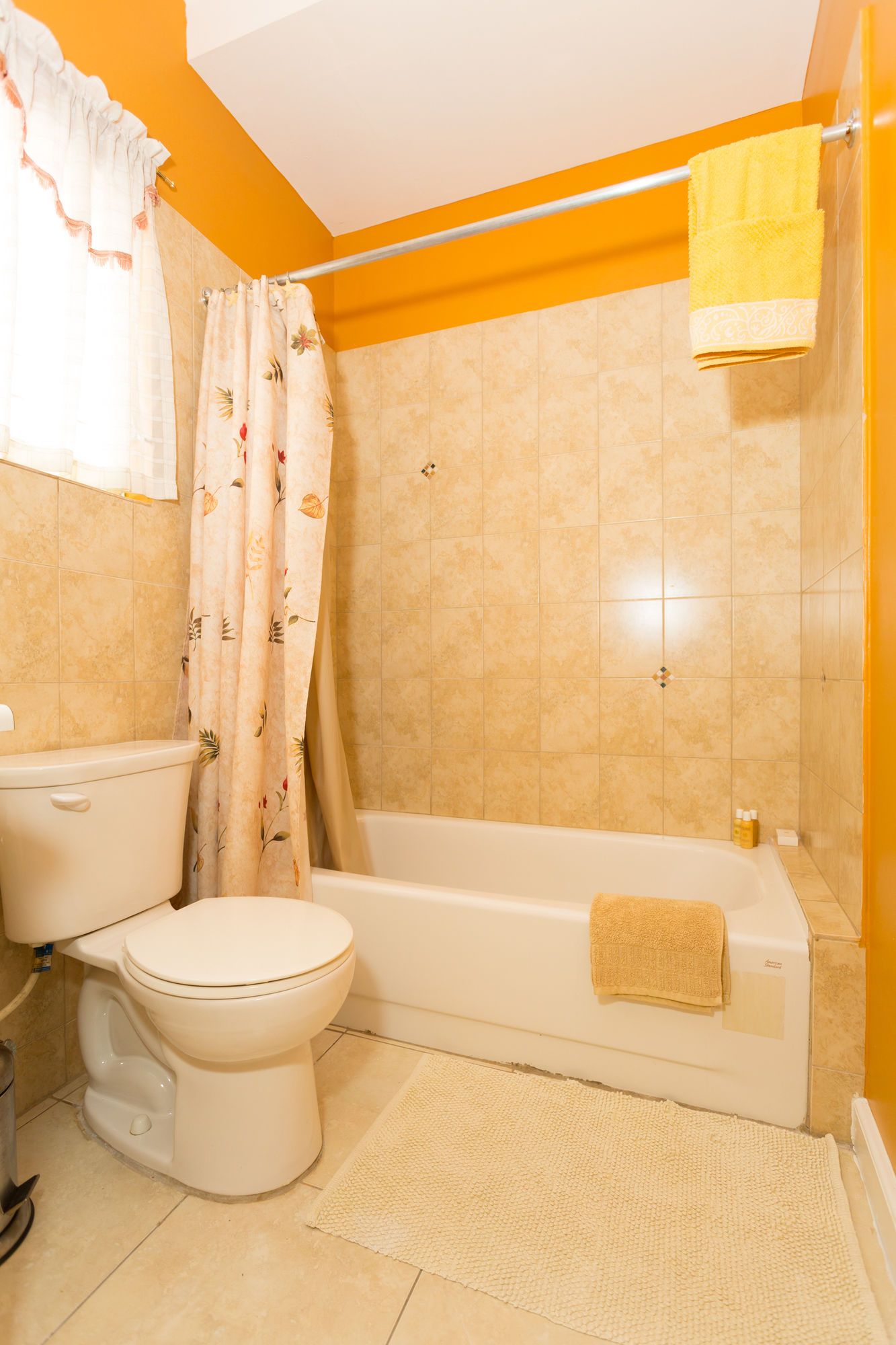Une salle de bain équipée de toilettes, d’une baignoire et d’un rideau de douche.