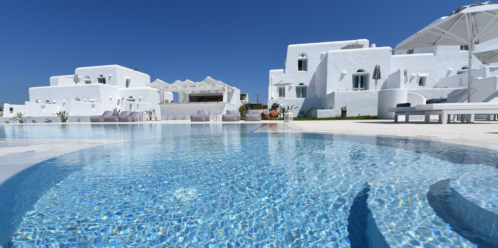 A swimming pool with white buildings in the background.