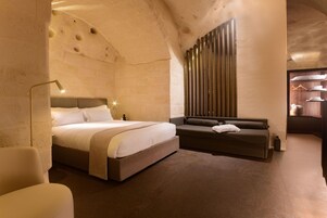 Una camera d'albergo con un letto, un divano, una lampada e un armadio.