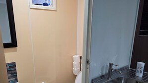 Ein kleines Badezimmer mit Toilette, Waschbecken und Fenster.
