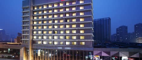 A multi-story hotel with a modern design, featuring a prominent signage at the top and a series of windows on each floor.