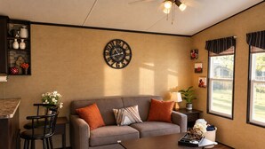 Una sala de estar con sofá, mesa de centro y un reloj de pared.