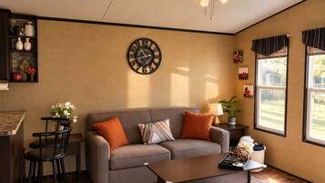 Una sala de estar con sofá, mesa de centro y un reloj de pared.