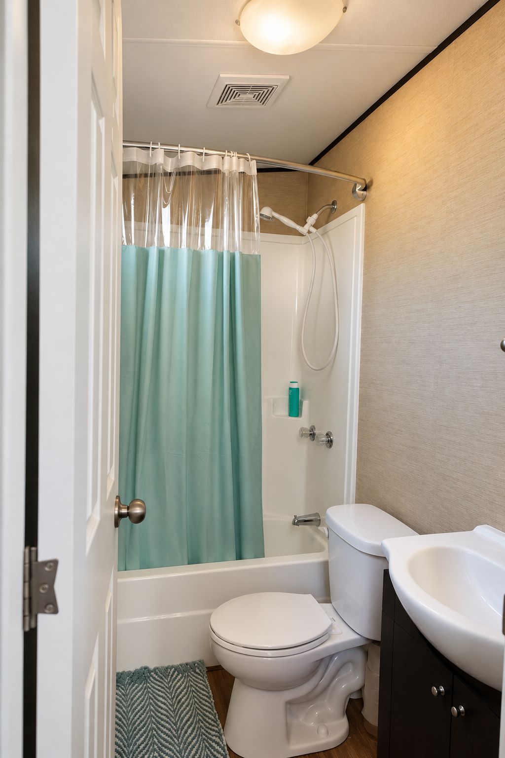 Un baño con ducha, inodoro y lavamanos.
