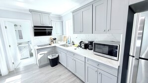 A modern kitchen with grey cabinets, a stainless steel refrigerator, a microwave, and a coffee maker. - Cozy 1-bedroom & 2beds house in Rowland Heights with AC near Disneyland Park (Rowland Heights)