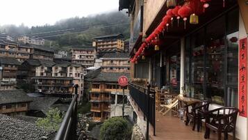 A traditional building with a balcony, wooden furniture, and red lanterns.