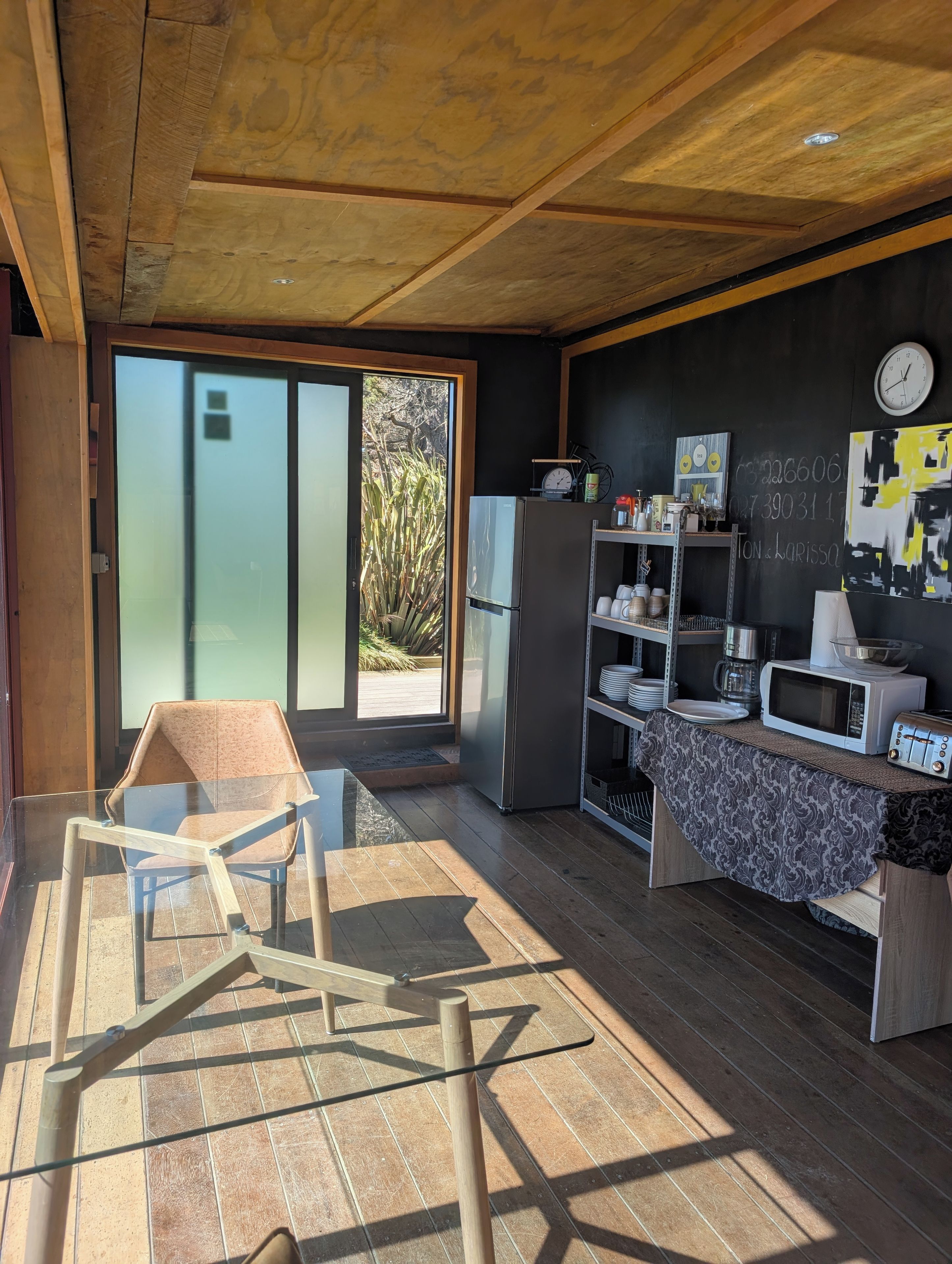 Eine moderne Küche mit Kühlschrank, Mikrowelle und Kaffeemaschine auf der Arbeitsplatte.