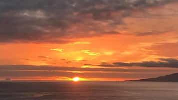 A sunset over a body of water with a distant landmass.