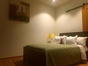 Una habitación de hotel con una cama, una lámpara y un cuadro en la pared.