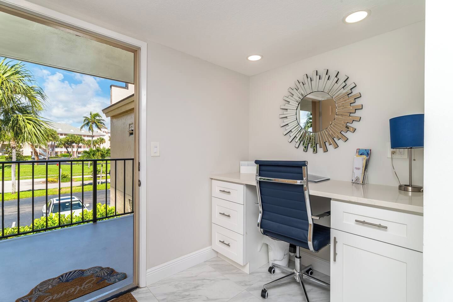 A modern office space with a desk, chair, and a decorative mirror.
