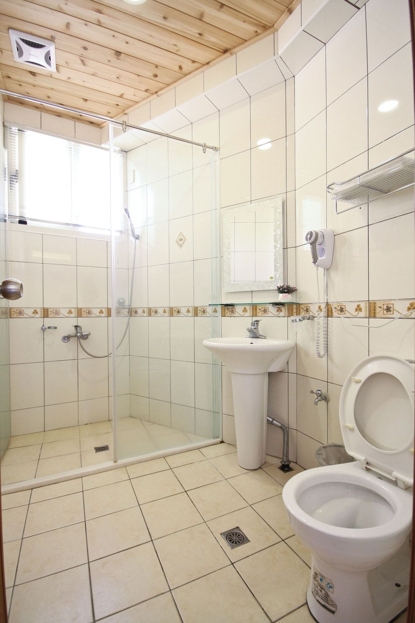 A bathroom with a shower, sink, and toilet.
