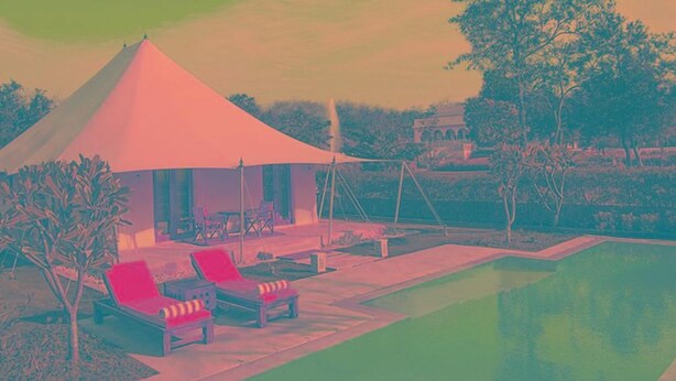 Ein überdachter Außenbereich mit Lounge-Möbeln und einem Pool.
