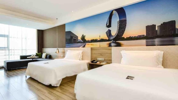 A hotel room with two beds, a large window, and a cityscape mural on the wall. - Atour Hotel Tianjin Teda (Tianjin)