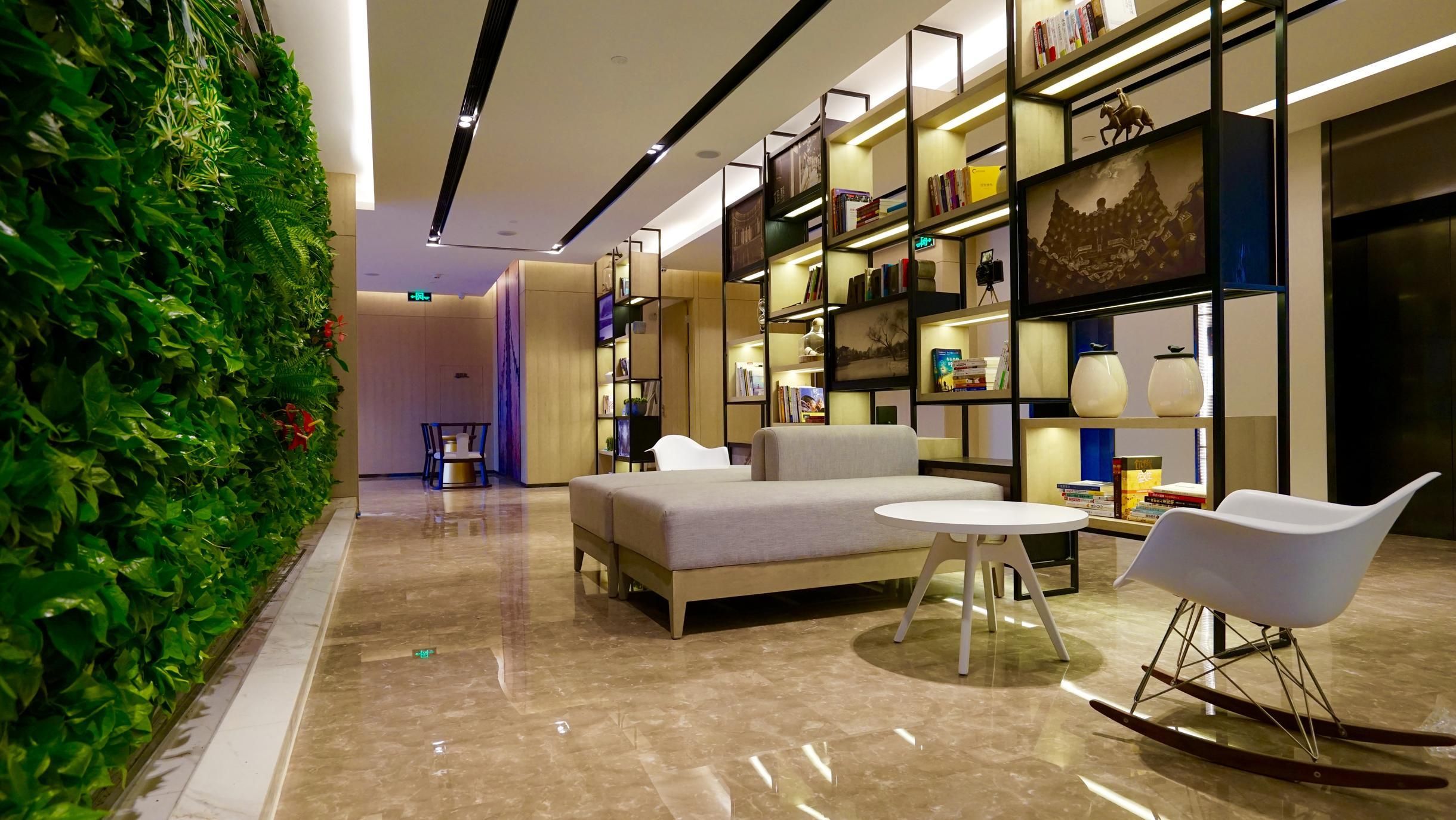 A modern lounge area with a sofa, a round table, and a rocking chair.