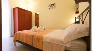 A bedroom with a bed, a wardrobe, a picture on the wall, and a staircase. - La Fontana di Rua Catalana (Naples)