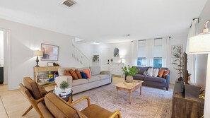 A spacious living room with a sofa, armchairs, a coffee table, and a TV. - Family stay near Live Oak Park with patio, pool table, & soaker tub (Live Oak)