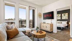 Una sala de estar moderna con un sofá, una mesa de centro y un televisor montado en la pared.