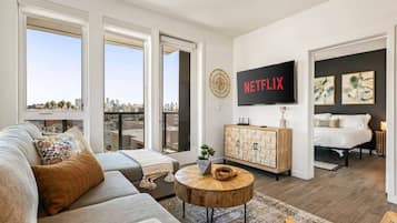 Un salon moderne avec un canapé, une table basse et un téléviseur fixé au mur.