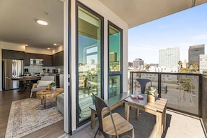 Eine moderne Wohnung mit Balkon, Küche und Essbereich.