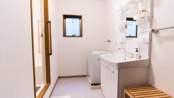 A compact bathroom with a sink, mirror, and a small window.